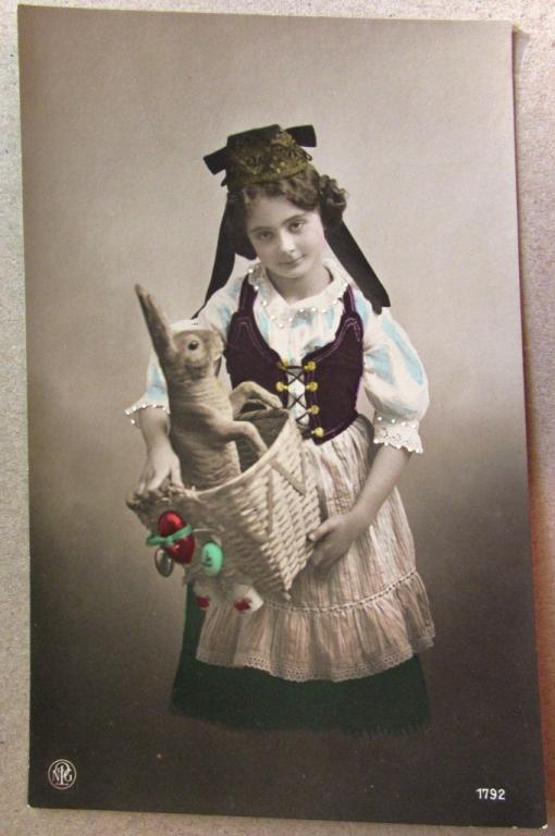 Девочка в национальной одежде с игрушечным зайцем в корзине