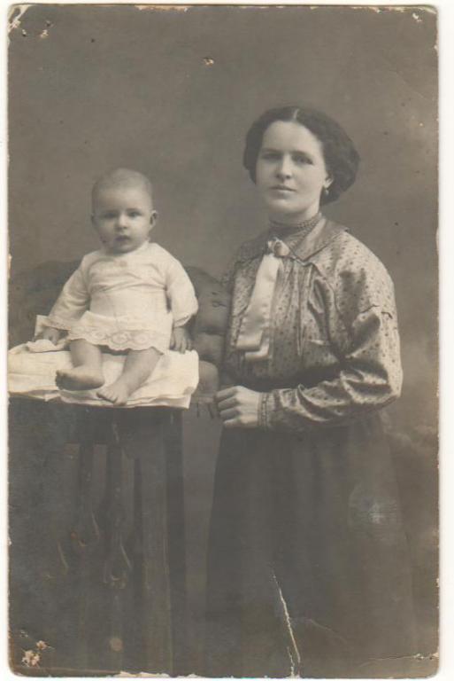 Фото молодой женщины и маленького ребенка на детском стульчике.