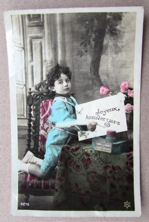 Мальчик в голубом костюме у стола с поздравительным письмом