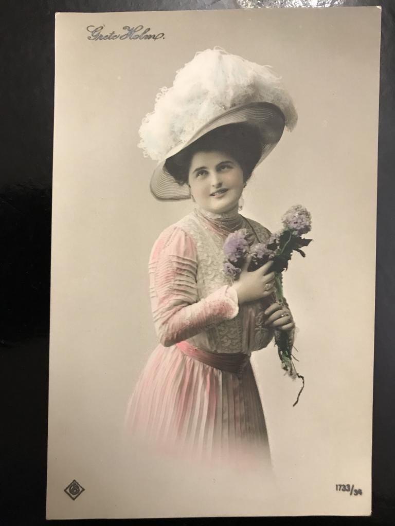 Девушка в шляпе с перьями и букетом в руках. Коллекция.