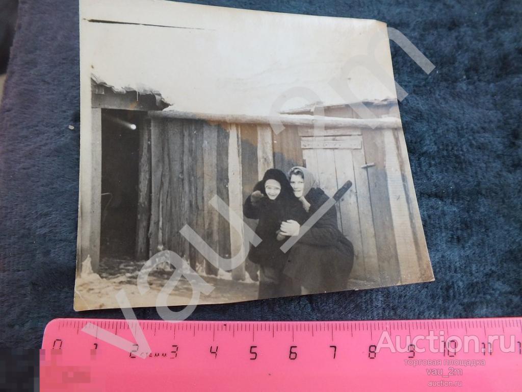 Женщина и ребенок зимой на улице на фоне деревенского сарая. и1 