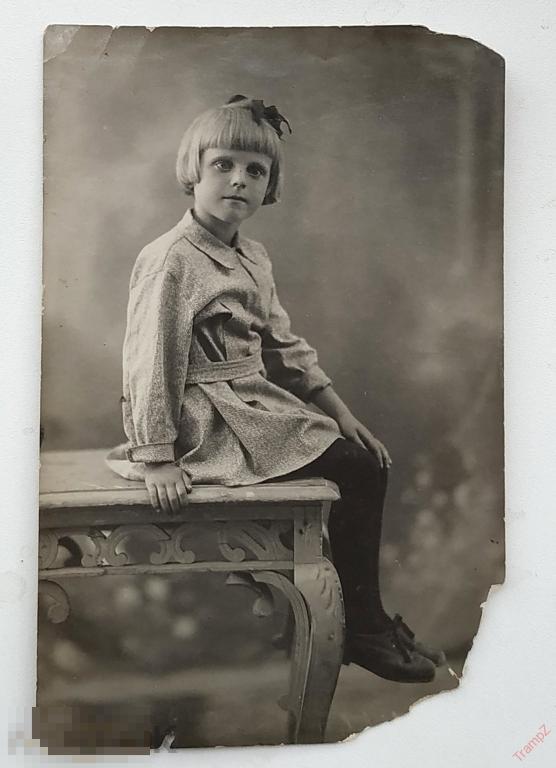 Фотография девочка в платье сидит на углу стола, мода прическа 1930-е #104 