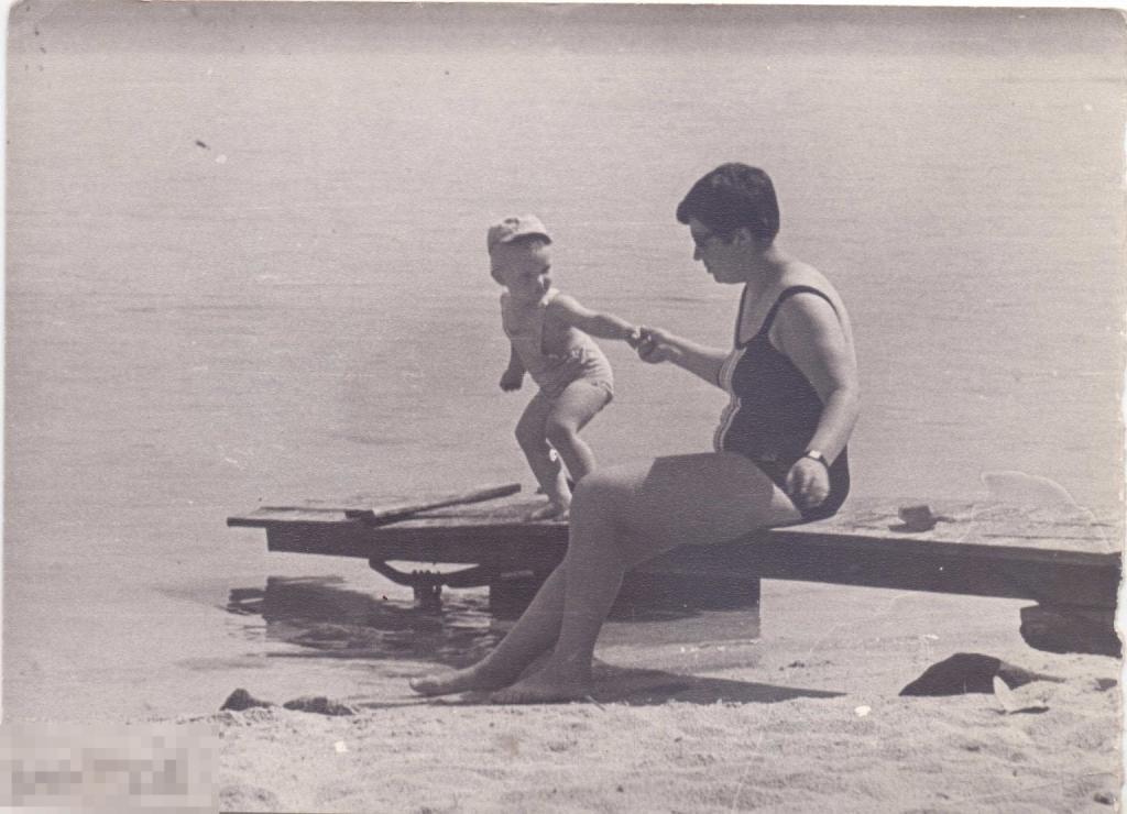 Женщина в купальнике с маленьким ребенком на песчаном пляже. 1960-70-е гг.