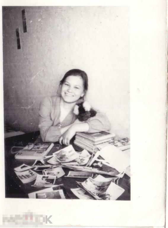 Девушка у стола с фотографиями. 1975 г.
