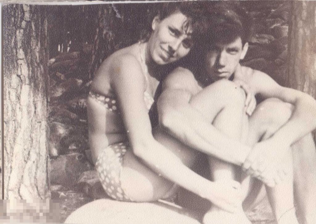 Юноша обнимает колени девушки в купальнике в лесу. 1960-е гг.