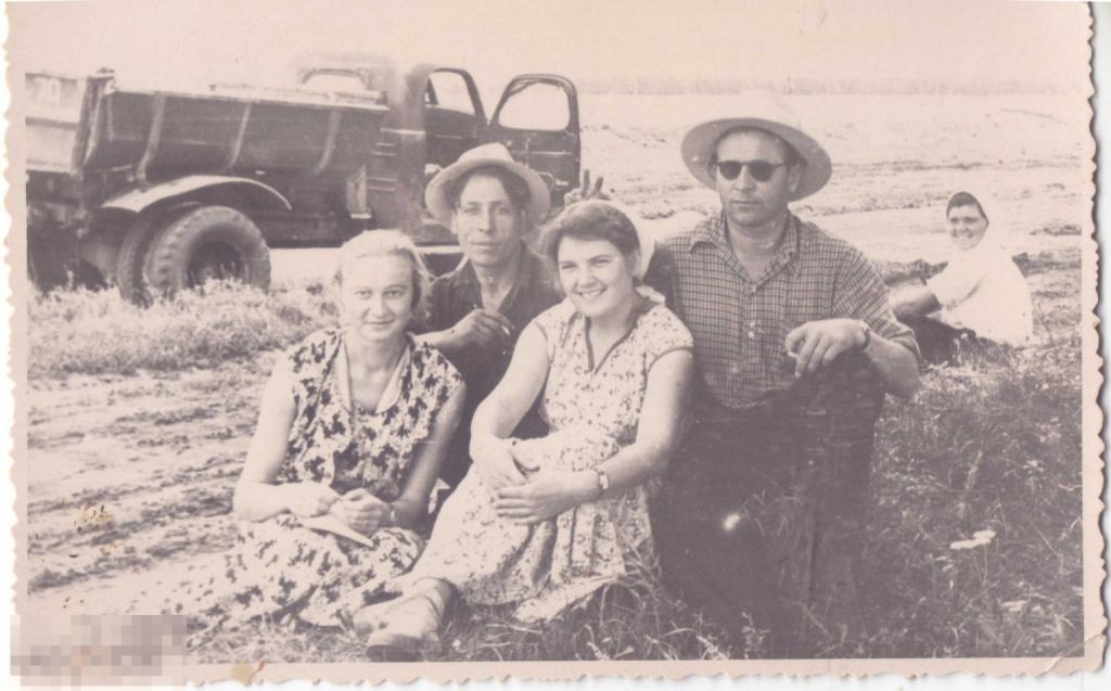 Мужчины и женщины на сельхозработах в поле на фоне грузовика. 1958 г.