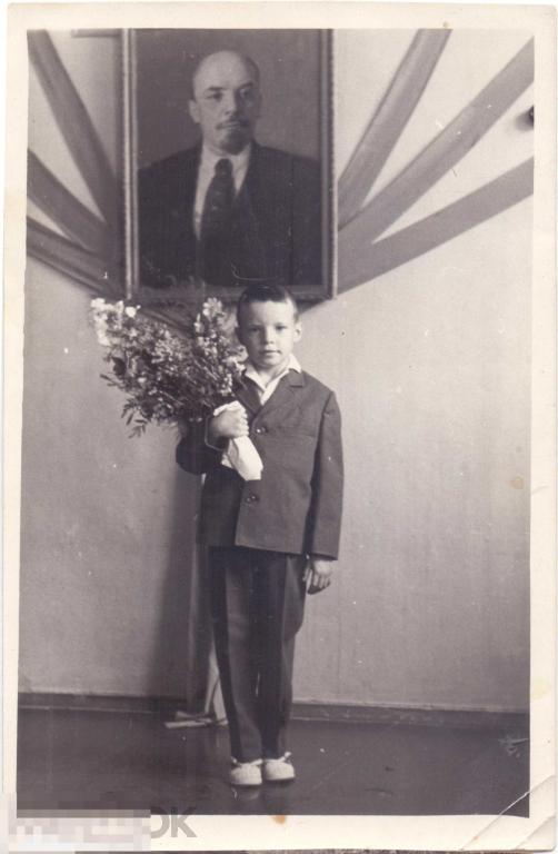 Школьник первоклассник с букетом цветов под портретом Ленина. 1950-е гг.