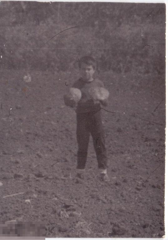 Маленький мальчик в поле с двумя грибами с большими шляпками. 1976 г.