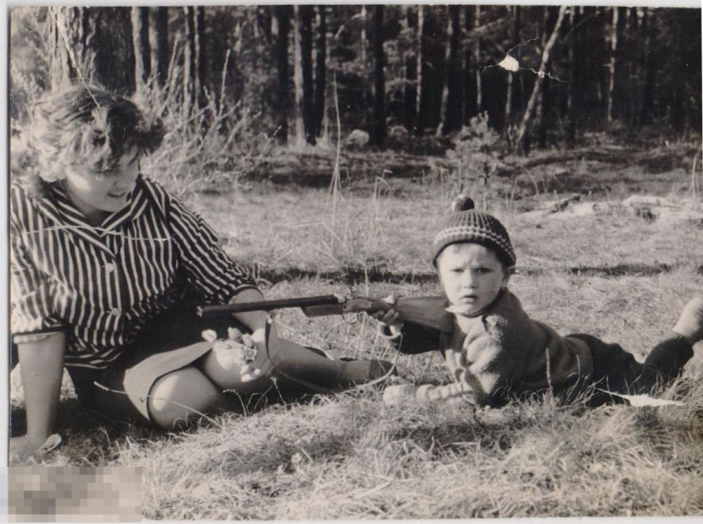 Маленький мальчик с игрушечным ружьем с мамой. 1960-е гг.