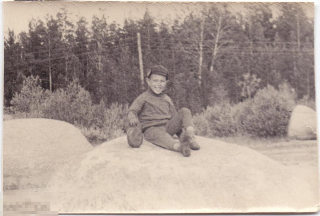 Маленький мальчик с фляжкой сидит на камне. Начало 1970-х гг.