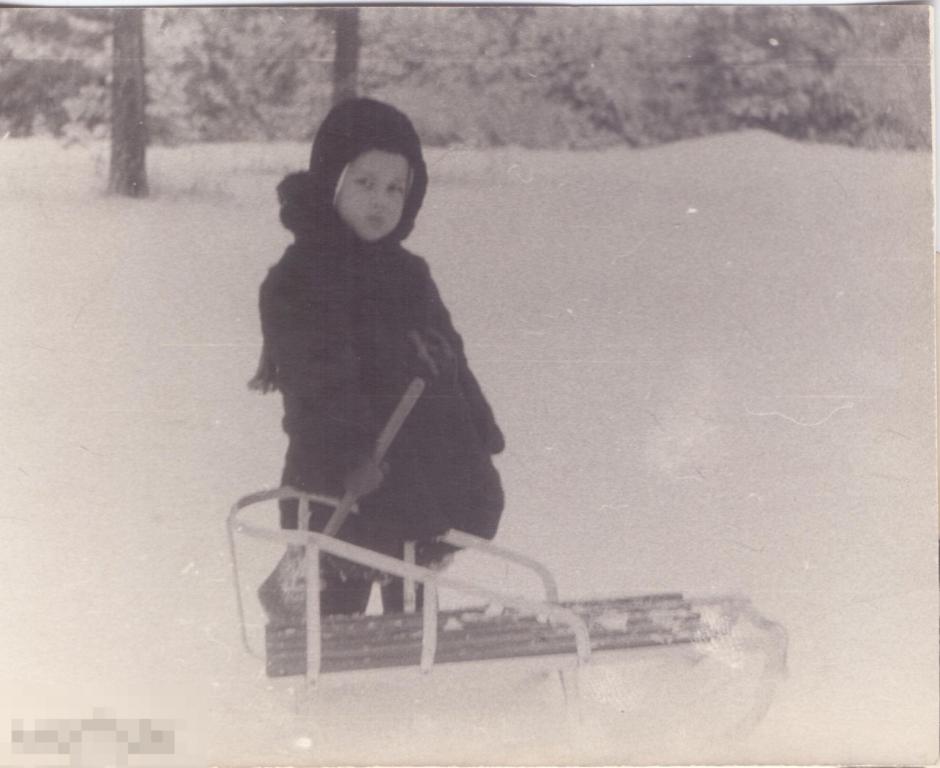 Маленький мальчик с лопаткой зимой у санок. 1960-е гг.