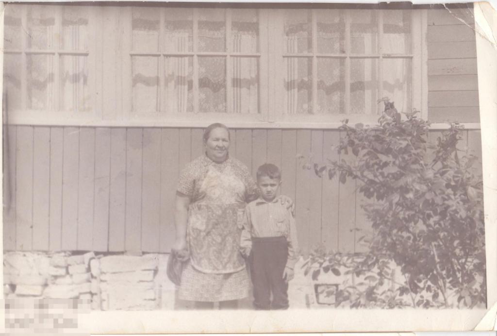 Бабушка с маленьким внуком у стены дачного домика. 1960-е гг.