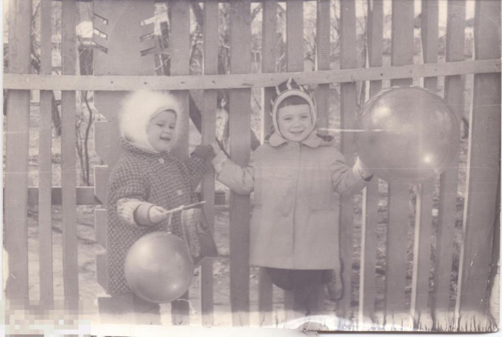 Маленькие дети с воздушными шариками у забора. 1960-70-е гг.