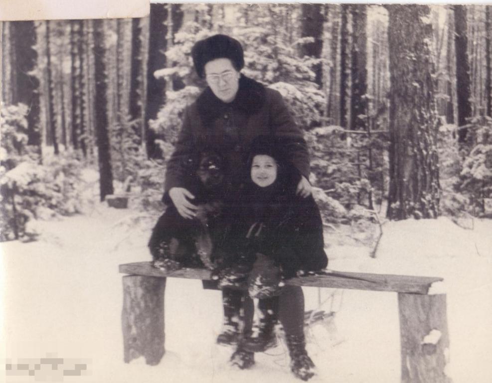 Мать с маленьким сыном на скамейке зимой в лесу. 1970-е гг.