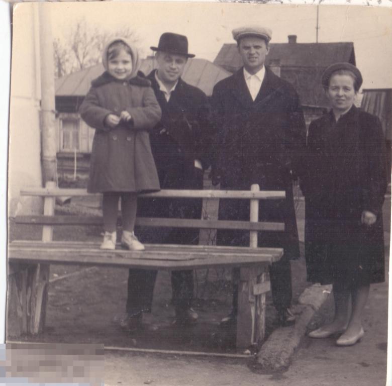 Женщина, двое мужчин и девочка, стоящая на скамейке ногами. 1950-60-е гг.
