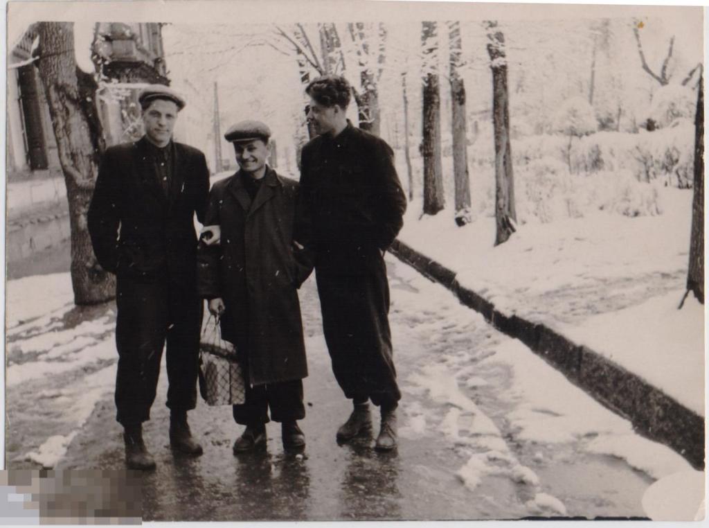 Трое юношей на заснеженной дорожке, один - с авоськой. 1950-е гг.