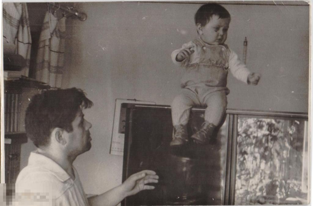 Маленький мальчик сидит на шкафе + отец. 1960-е гг.