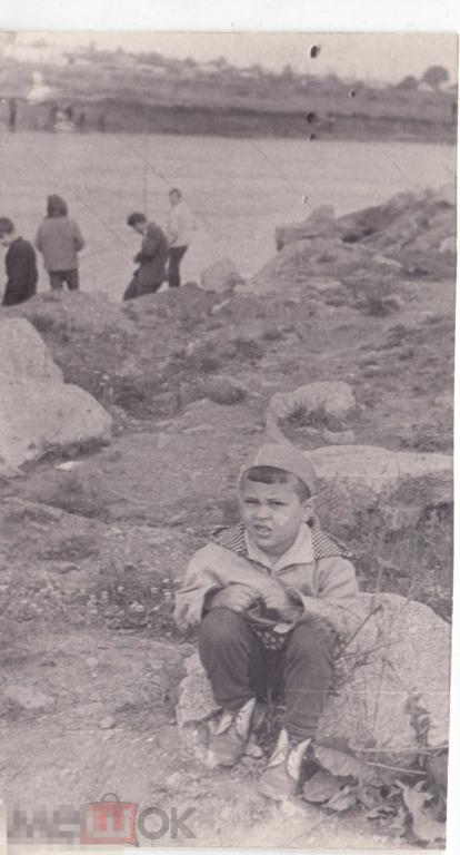 Маленький мальчик сидит на камне на берегу реки. Начало 1970-х гг.