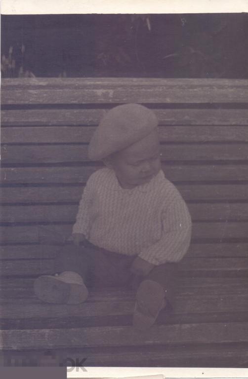 Маленький мальчик в берете сидит на скамейке. Затемнена. 1960-е гг.
