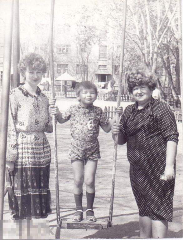 Маленький мальчик на качелях с мамой и бабушкой. 1970-80-е гг.