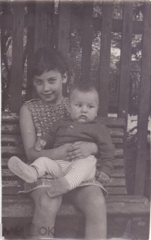 Девочка с маленьким мальчиком на руках сидит на скамейке. 1960-70-е гг.