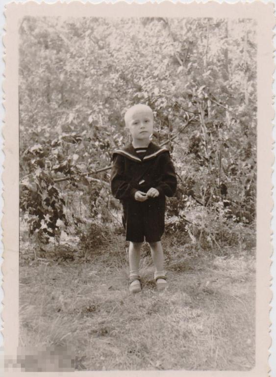 Маленький мальчик в матроске на фоне кустов. 1950-1960-е гг.