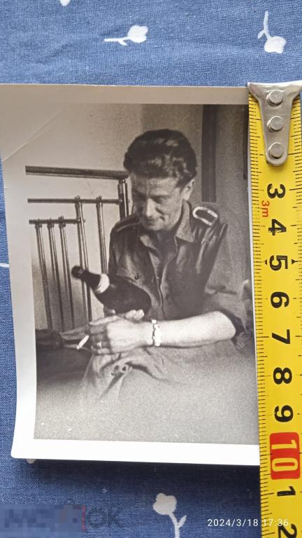 ВОВ. Немец солдат на кровати с бутылкой вина. Часы, перстень, сигарета. Солдатский быт.