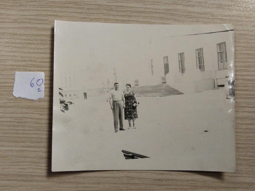 Фотография "Пара на фоне здания. (Пересвеченная) СССР. 60-е годы."